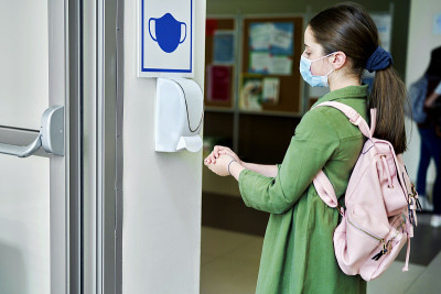 女学生戴上防护口罩消毒双手