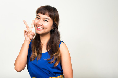 亚洲妇女的肖像微笑和做和平的手势