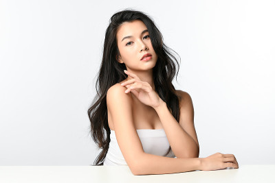 美丽年轻的亚洲女性与干净的新鲜皮肤在白色的背景，面部护理，面部治疗，美容和水疗中心，亚洲女性肖像。