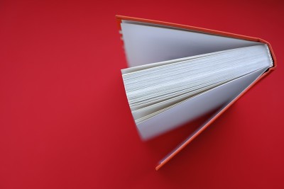 读书。学习与知识观念。红底红封面的书。书关闭。本页面宏。俯视图，复制空间