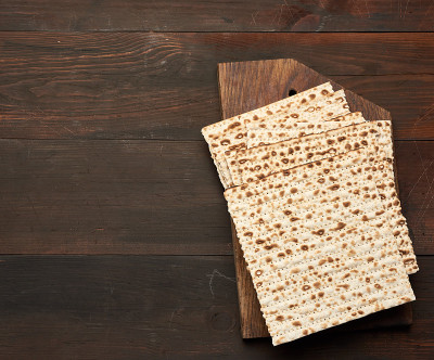 stack of baked square matzo on a brown wooden back