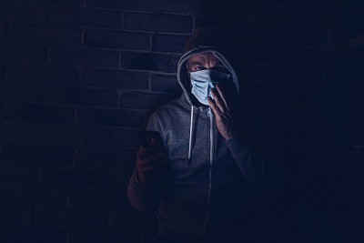 惊恐的男子在智能手机上阅读covid-19冠状病毒信息。