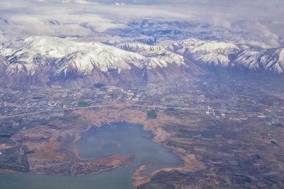 从飞机上鸟瞰瓦萨奇前落基山脉的雪峰在冬天包括城市普罗沃，法明顿Bountiful, Orem和盐湖城