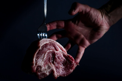 人手和件重画猪肉颈肉在叉子上深色的背景