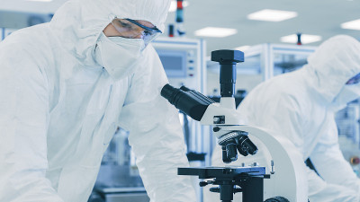 在实验室科学家穿着防护服做研究，使用显微镜和记录数据。工人在一个现代制造生产半导体和药品。