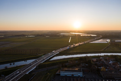 日出时分，荷兰北布拉班特Waalwijk附近，一座高架桥横跨A59公路的运河