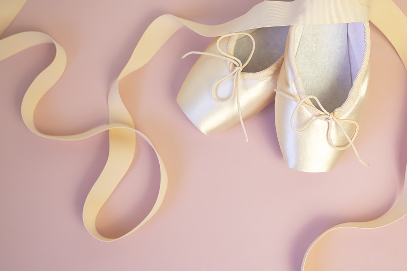 Pink ballet pointe shoes with ribbons on pink back