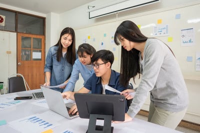 大学生在课堂上用笔记本电脑讨论专题