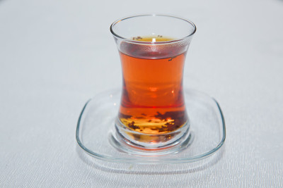 阿塞拜疆传统armudu茶梨形玻璃杯。阿塞拜疆红茶与复古的白色桌子。土耳其黑茶梨形杯，阿塞拜疆传统芳