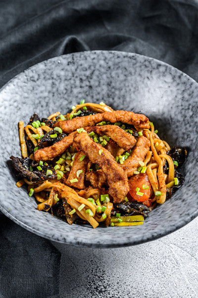 乌冬炒面，猪肉和蔬菜。白色背景。俯视图