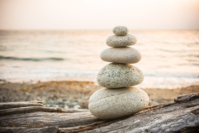 Inukshuk Cairn在海滩上的浮木上