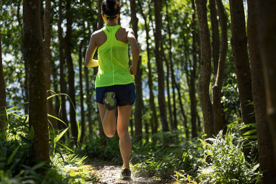 年轻女子trail runner在日出热带森林跑步