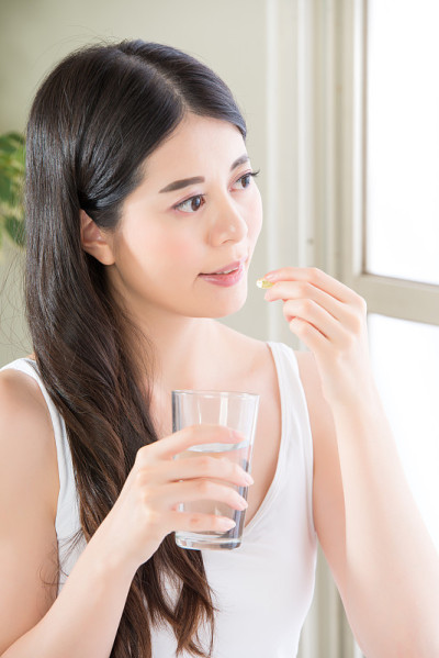美丽的亚洲女性喝水吃营养补品