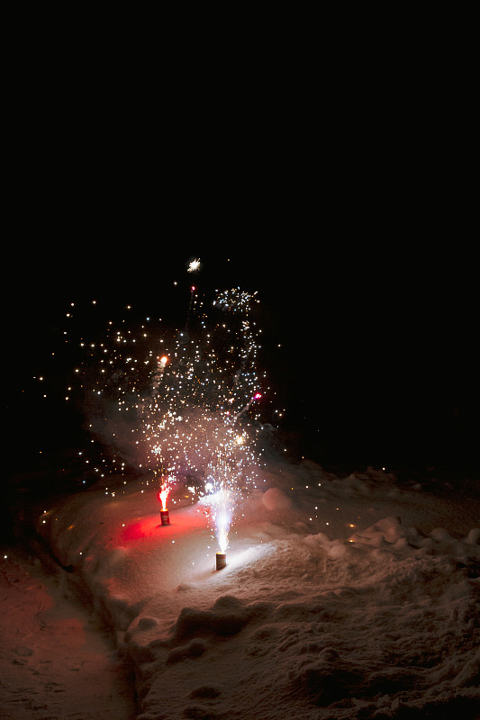 绚丽多彩的烟花喷泉在夜晚的雪地里