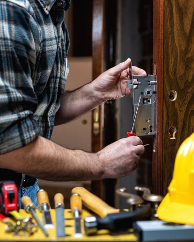 Carpenter at work repairs and installs the door lo