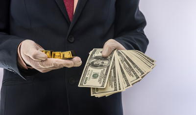 商人为了安全，把美元和金条放在医用手套里