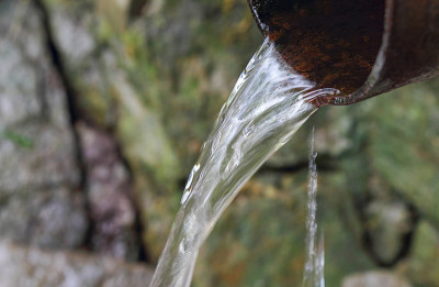 清澈的泉水，水流淙淙。水在石头上。在旅行或野餐时要照顾好大自然。环保的概念。选择性聚焦，复制空间。