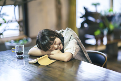 一个年轻女子在一个相当明亮的房间里打盹