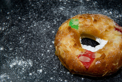 Roscón de reyes，传统的西班牙三国王蛋糕，奶油和节日装饰。三王的一天。黑色背景，撒上面