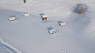 野餐桌上盖满了雪花，雪花飘落后，无人机鸟瞰