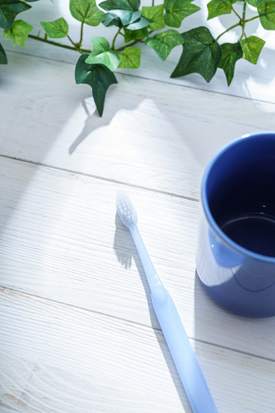 牙刷和杯子放在木桌上