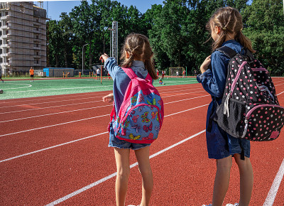 小学生们在学校体育场观看他们如何踢足球。