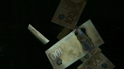 落在空中的加拿大元钞票上的黑色背景。高质量的跌落美元钞票