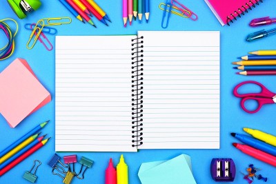 打开，空白的笔记本与学校用品框架在一个蓝色的背景