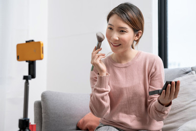 著名的亚洲美容博主正在录制化妆教程和美容技巧。