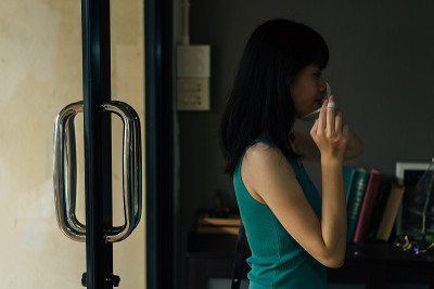 一名亚洲妇女回家时摘下防护面具