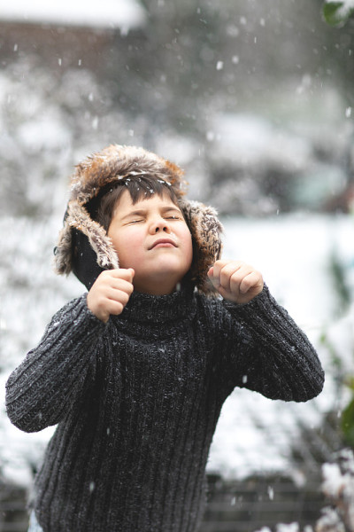 小男孩试图用舌头接住雪。