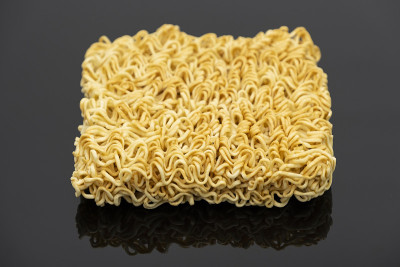 生方便面准备煮孤立在黑色背景