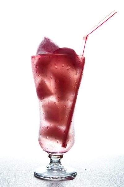 冰糕玻璃杯，红色的冰和稻草在白色的背景