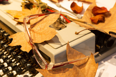 eyeglasses on a typewriter with autumn leaves in t