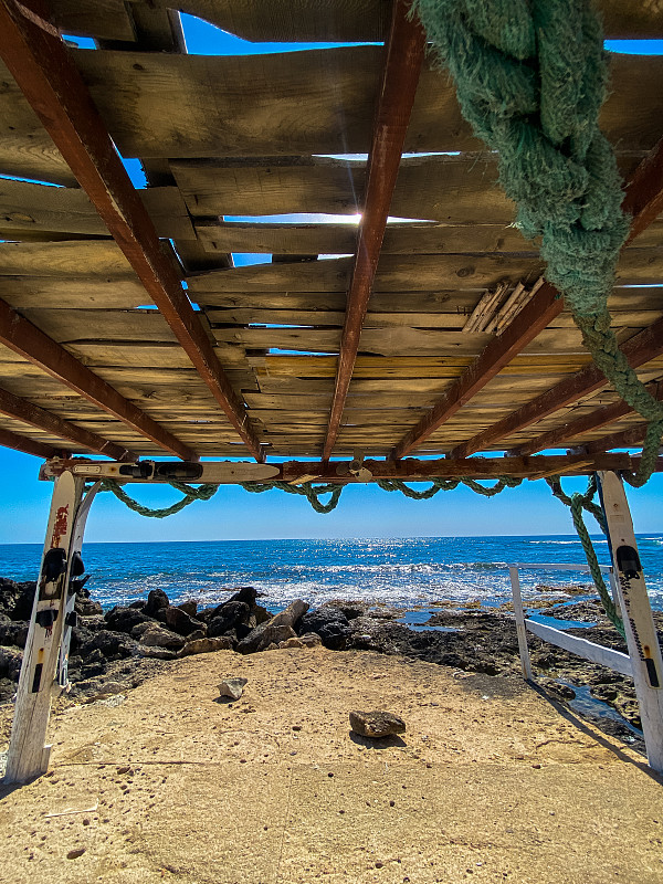 海浪，地中海的蓝色波浪在塞浦路斯。洛奇用石头打死海滩。夏天的一天。阳光灿烂的天堂。阳光明媚的白天海景