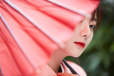 穿着和服，带着红色日本伞的年轻女子
