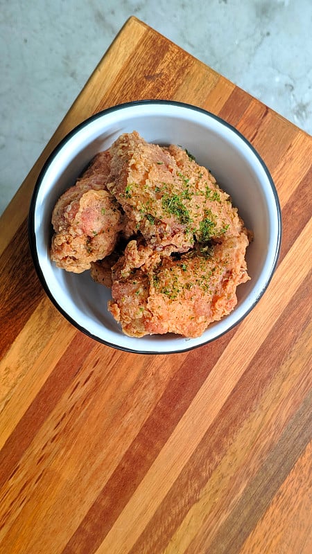 Bowl of popcorn chicken on wooden table