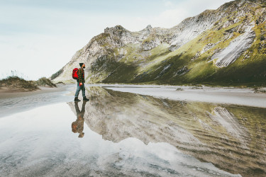 独自行走在山区沙滩上的人旅行生活方式情感概念冒险户外夏日度假野生自然水的倒影