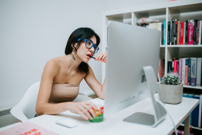 戴蓝眼镜在家用电脑工作的女人