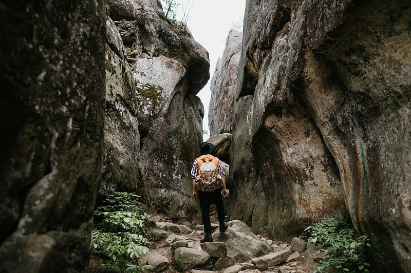 山徒步旅行。旅游者背着背包在峡谷中徒步旅行