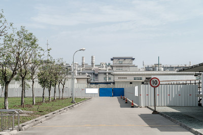 厂房位于市郊，以工业厂房为背景