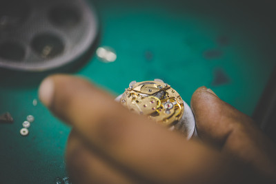 一个手表制造商用精密工具修理坏了的手表的近距离图像
