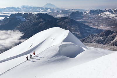 玻利维亚，登山者徒步攀登雪道山脊。