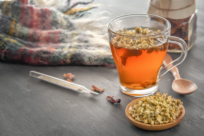 灰色的木桌上放着草药甘菊茶