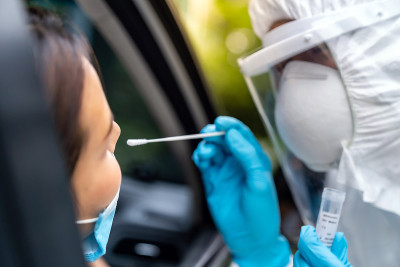 Asian woman Drive Thru COVID-19 testing with PPE m