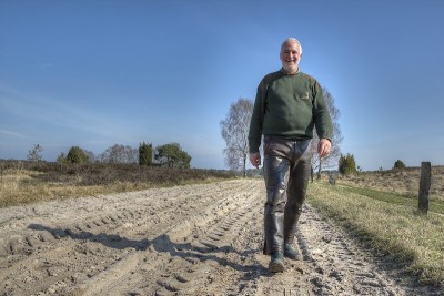 在Lüneburg荒地上的徒步旅行者在沙地小径上。
