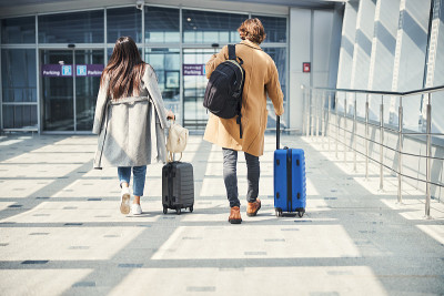 在机场提着旅行箱的时尚男士和女士