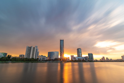 美丽的多云日落在城市池塘。长时间曝光的叶卡捷琳堡城市景观，俄罗斯与摩天大楼反映在水中