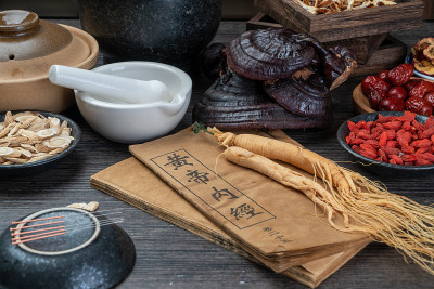 桌上放着古老的中医书籍和草药