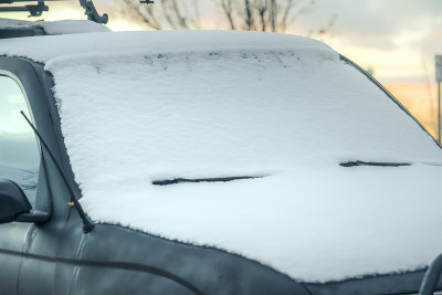 一辆雪白的黑色车辆的特写与地平线在日落的背景
